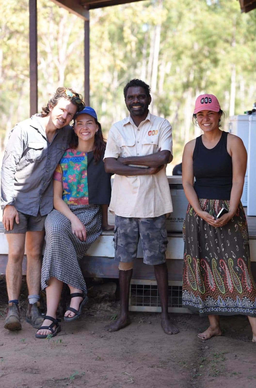 Four people beside a Pakkimjalki Kari washing machine, Maningrida