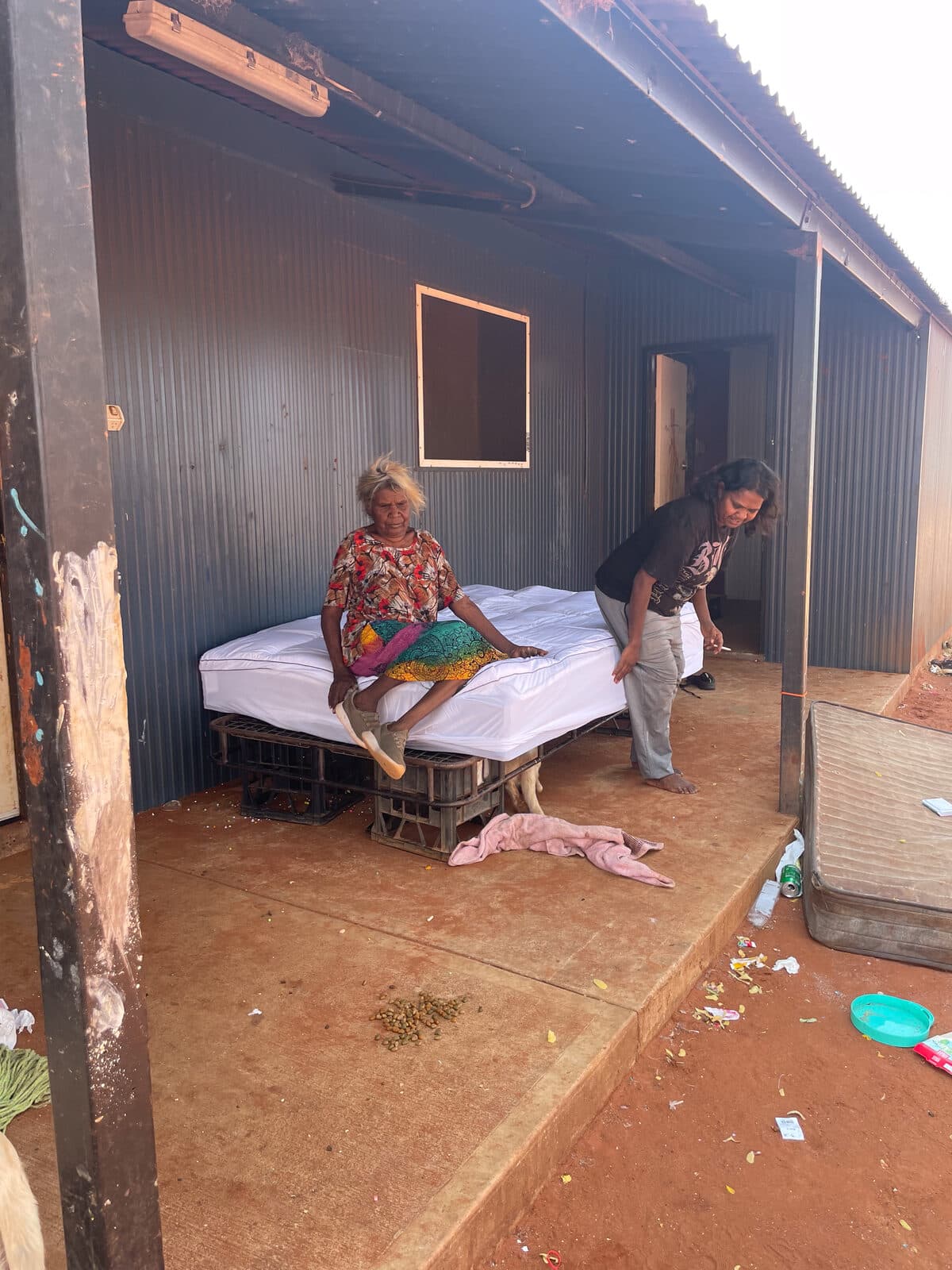 A bed set up outside a home at Utopia Homelands