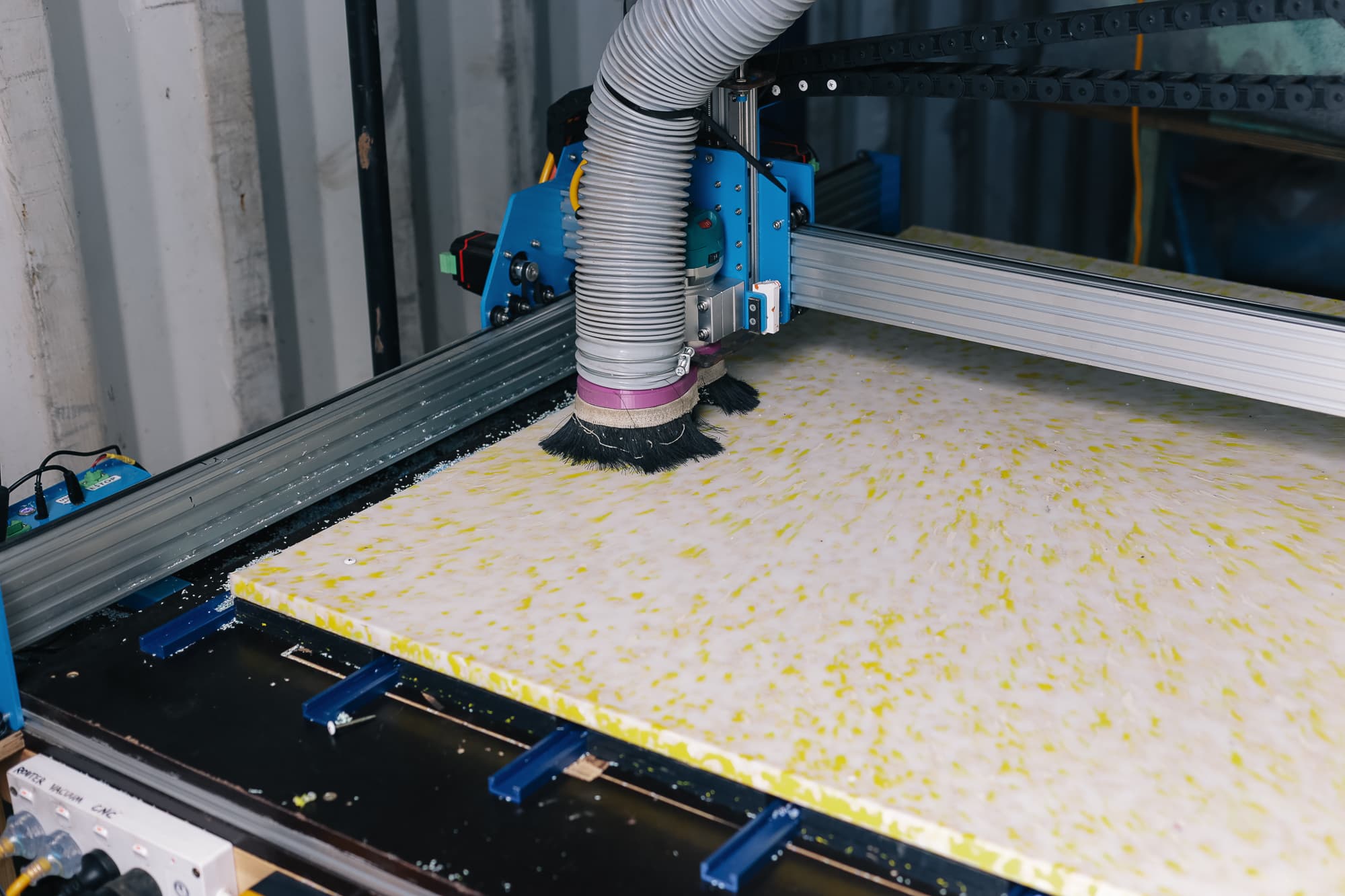 CNC router cutting bed leg components from pressed plastic sheet