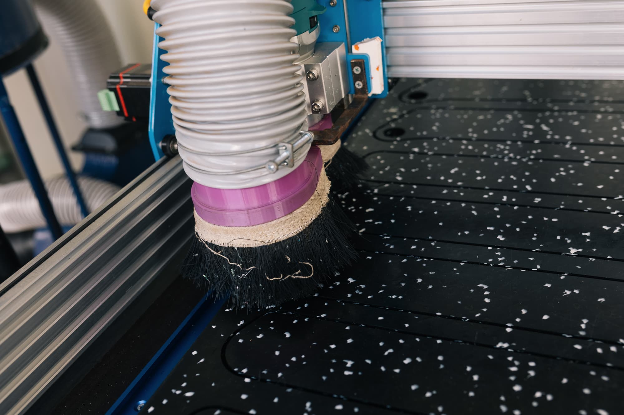 CNC router head mid-cut on a pressed HDPE sheet