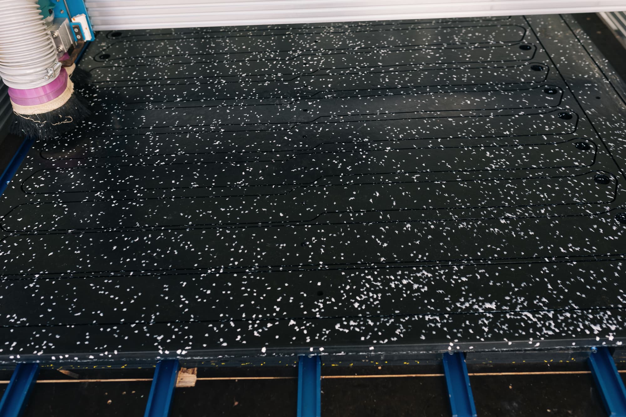 A pressed HDPE sheet loaded onto the CNC bed ready to cut